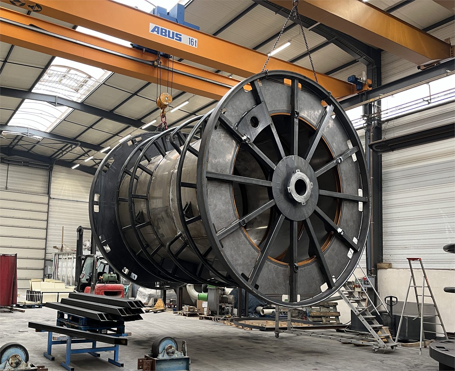 Bobine de câble en cours de fabrication, suspendue au pont roulant de l'atelier