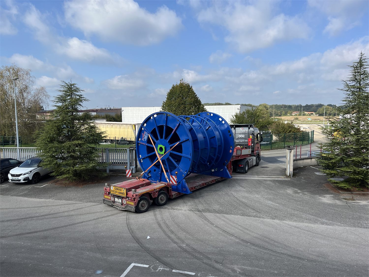 Bobine de câble peinte en bleu, arrimée sur une remorque de convoi exceptionnel